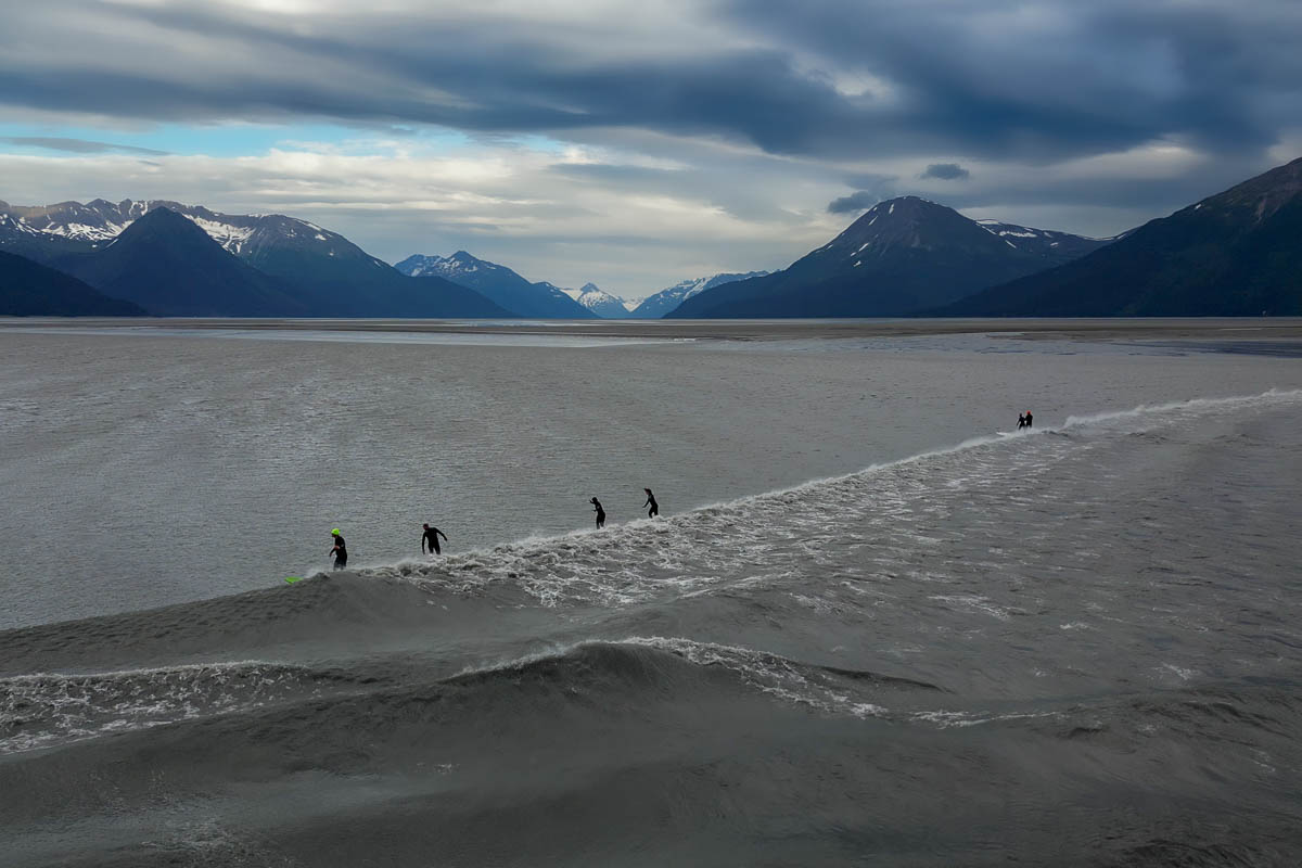 People surfing on the bore tide in the Turnagain Arm along the Seward Highway, Alaska