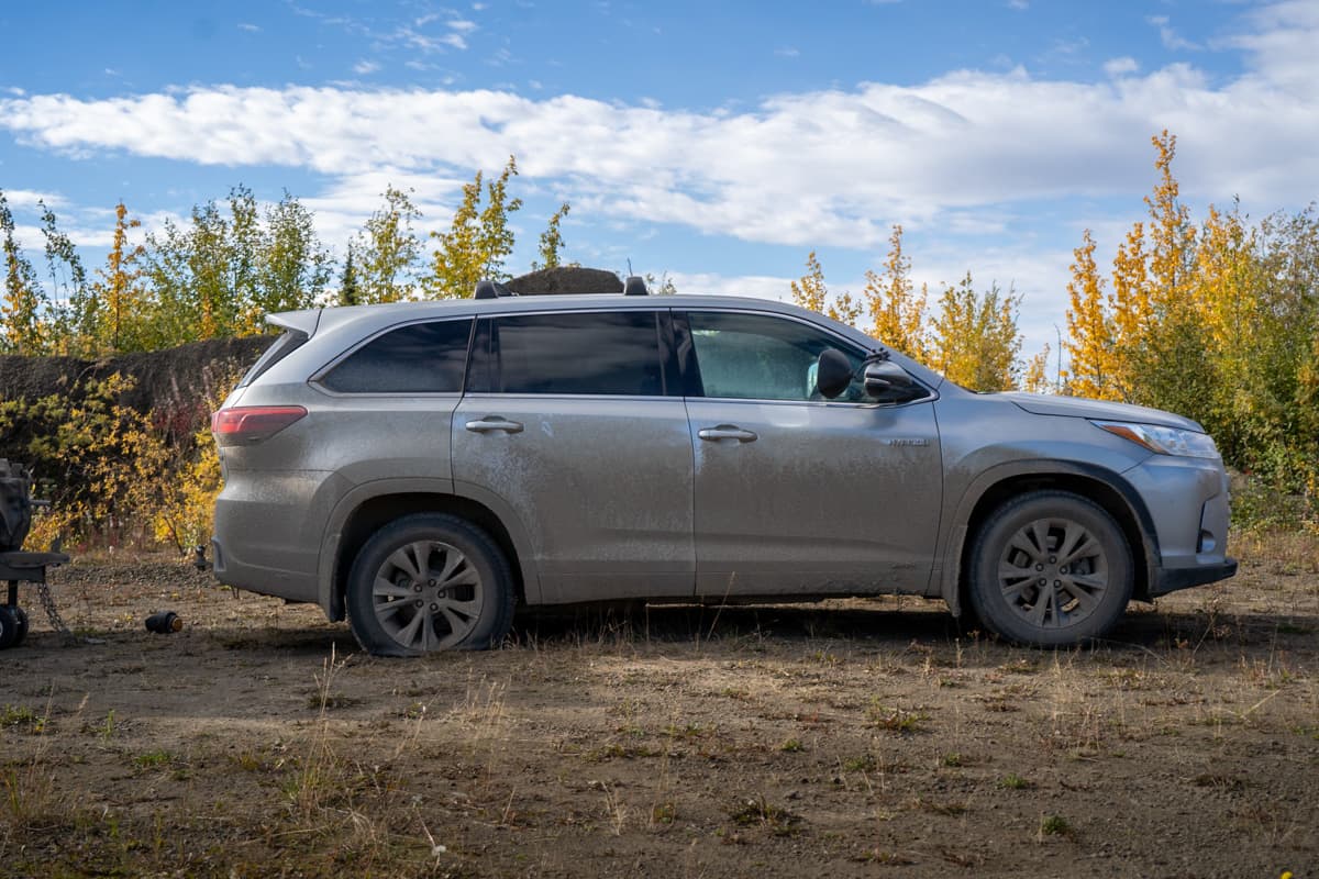 Highlander Hybrid with a flat tire parked in a tundra along the Dempster Highway in the Yukon Territory of Canada