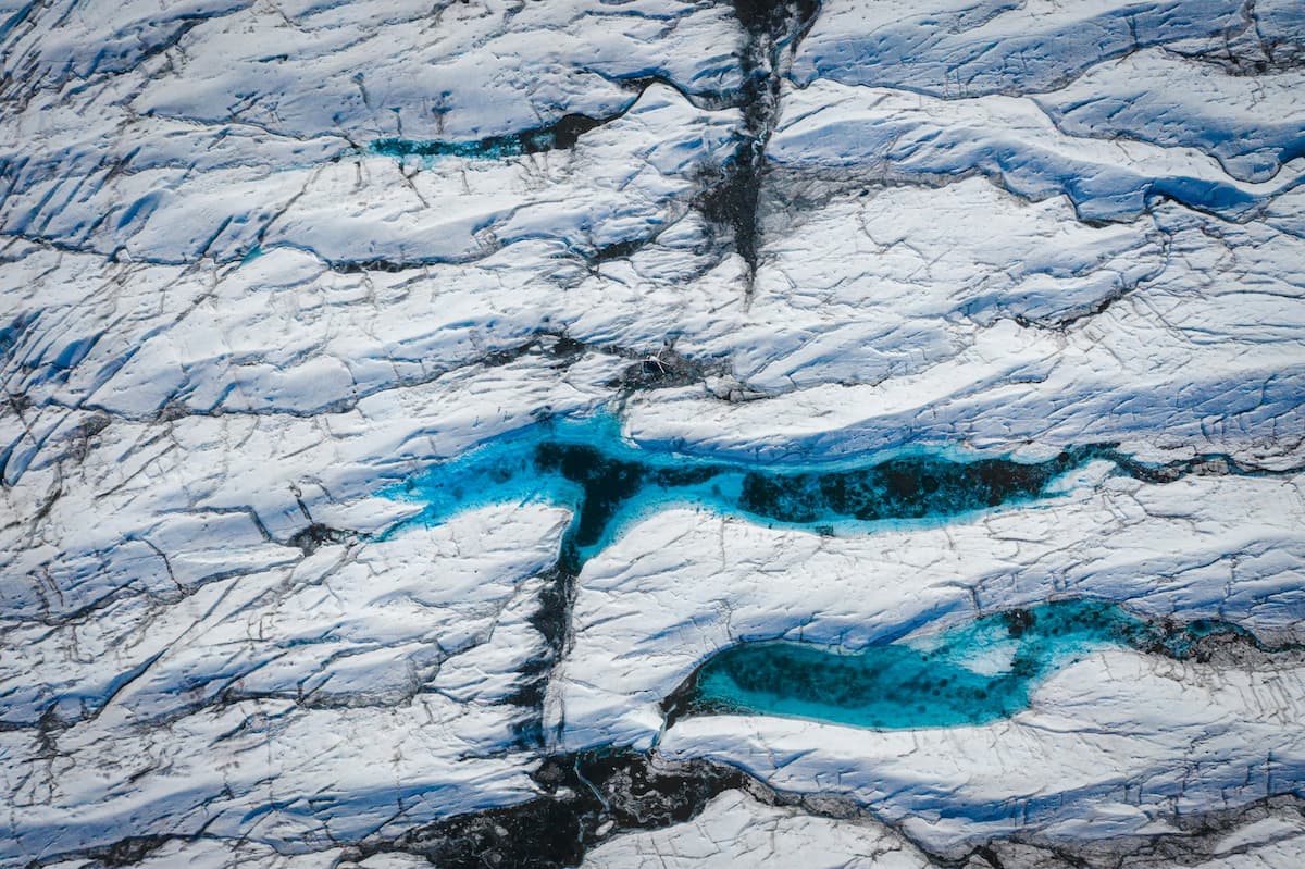 Aerial view of pool of turquoise meltwater on a glacier in Alaska
