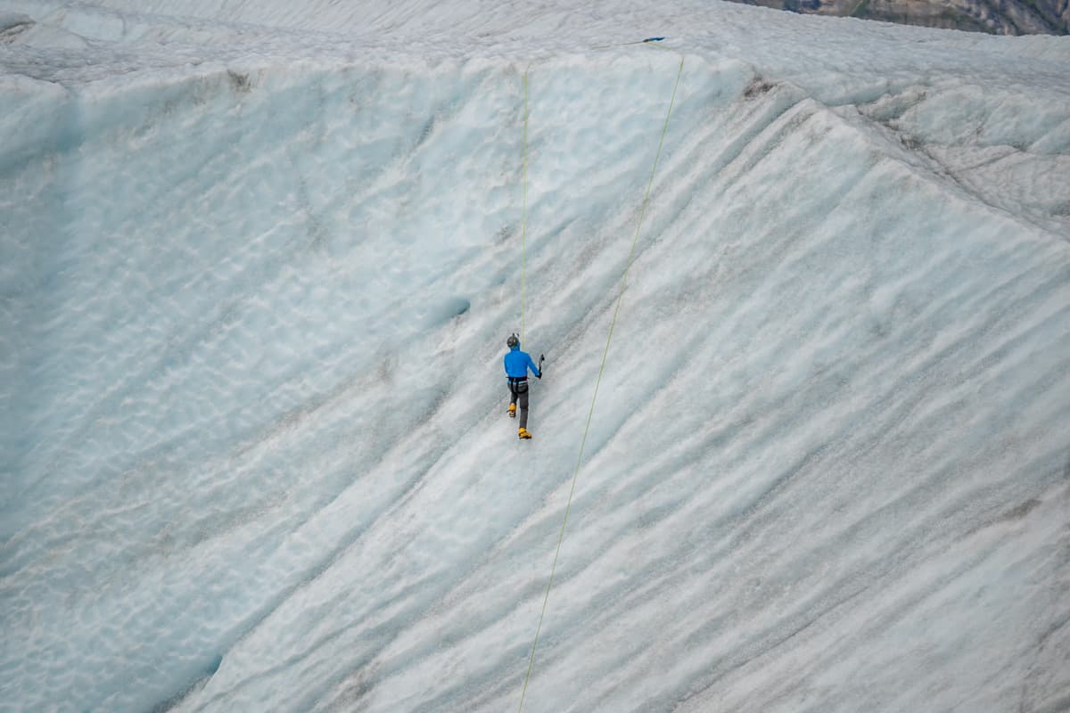 Man ice climbing a glacier in Alaska