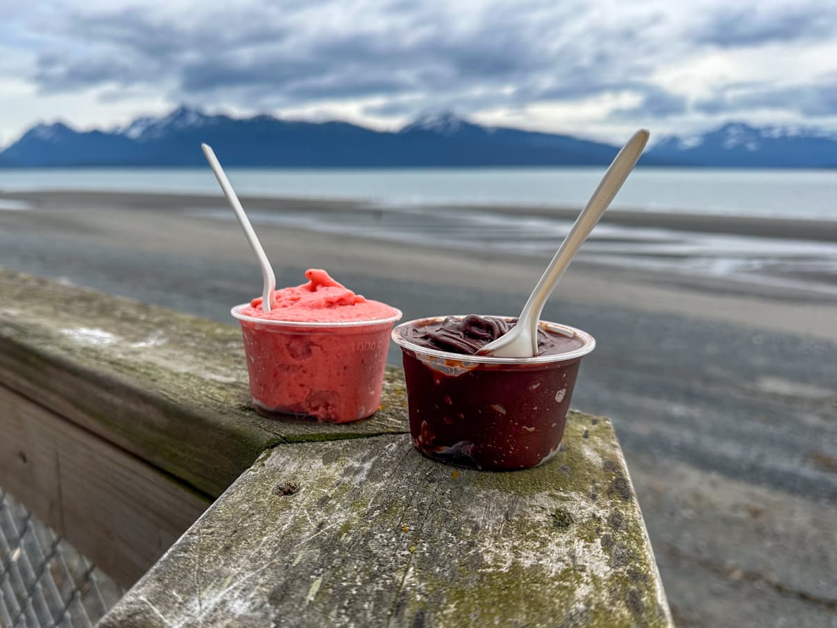 Two gelatos on a wooden railing with Kenai Mountains in the background in Homer, Alaska
