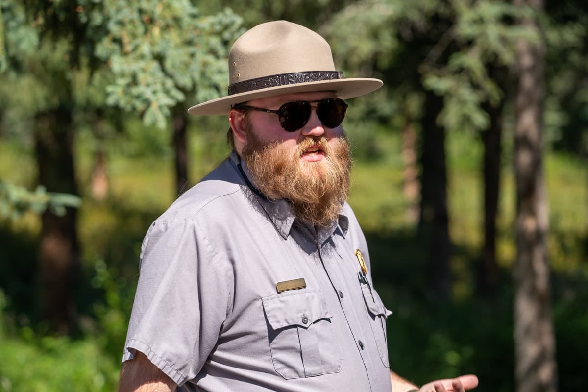 Ranger talking in front of pine trees in Denali National Park