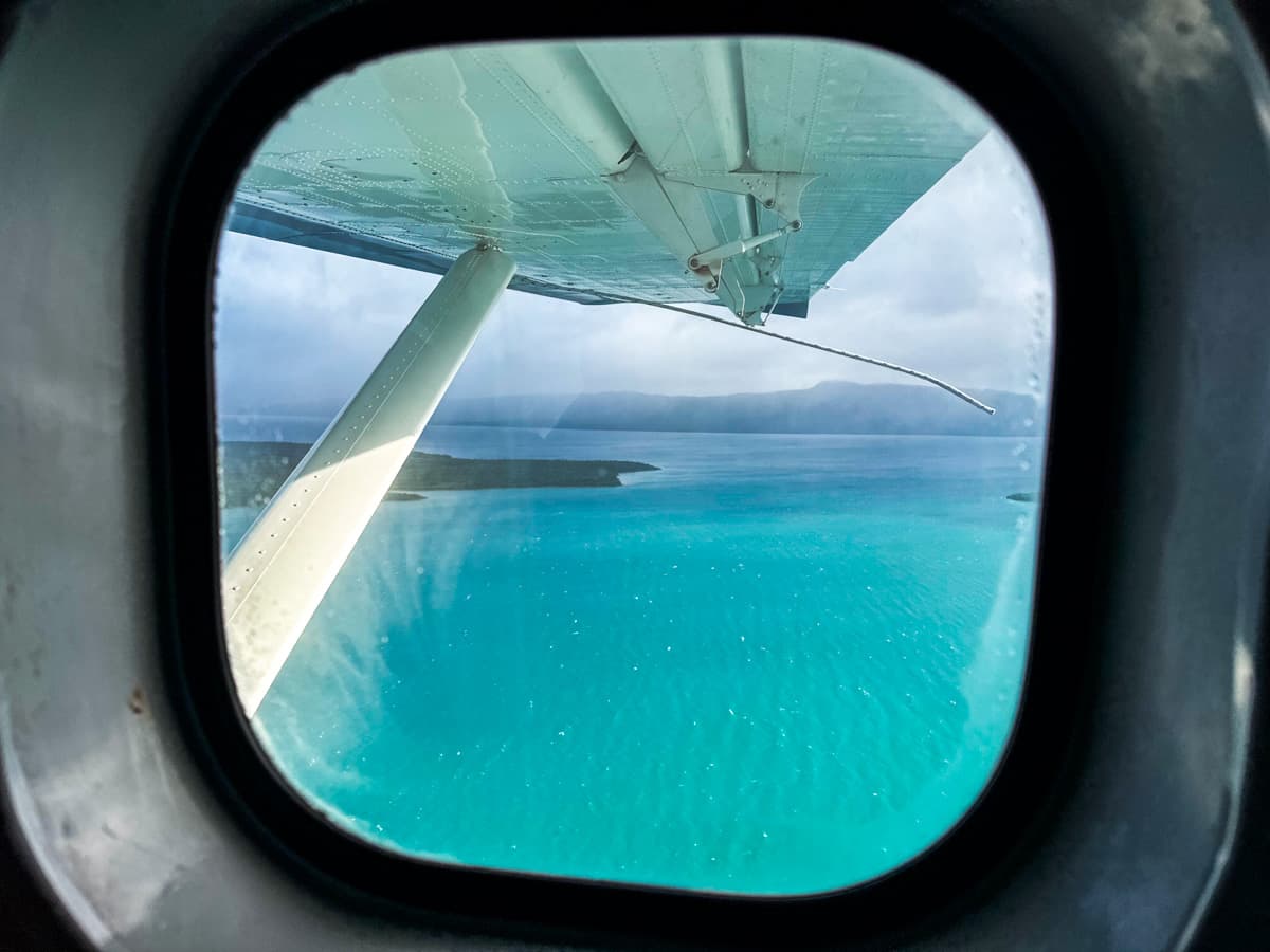 View out of a window overlooking turquoise water in Naknek Lake in Katmai National Park, Alaska