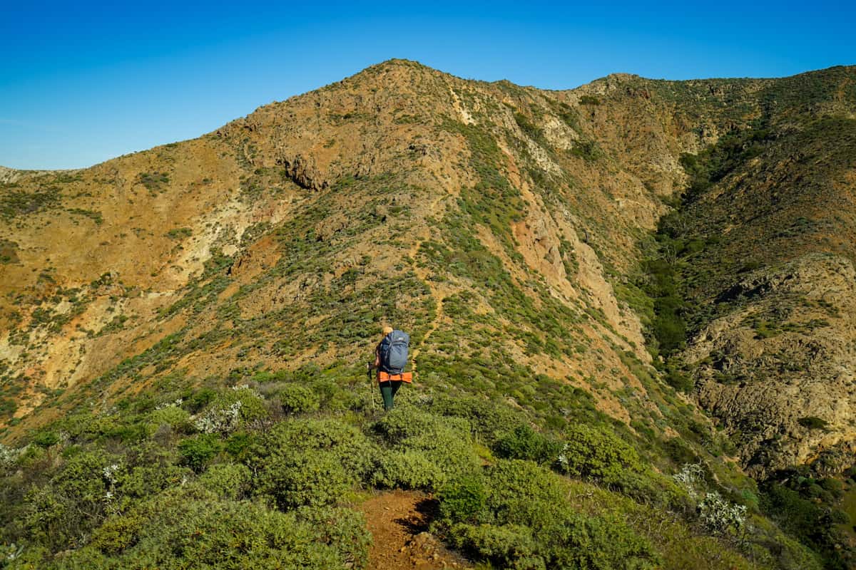 Woman hiking up High Mount on Santa Cruz island in the Channel Islands National Park, California