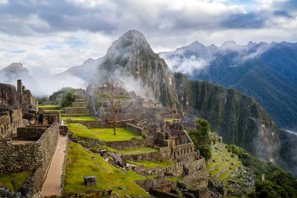 Ancient Inca ruins at Machu Picchu with low hanging clouds in the Andes Mountains in Peru