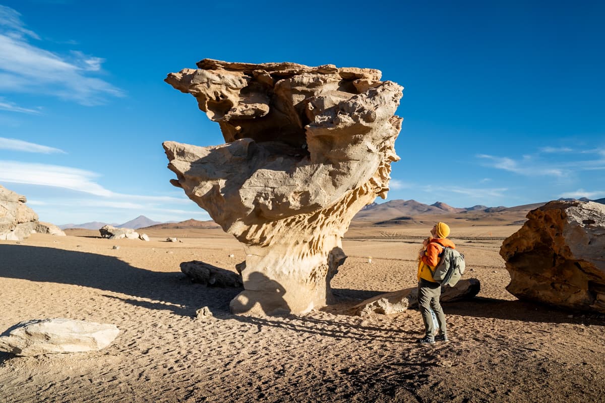 Man standing under the Árbol de Piedra in Eduardo Avaroa Andean Fauna National Reserve in Boliviae