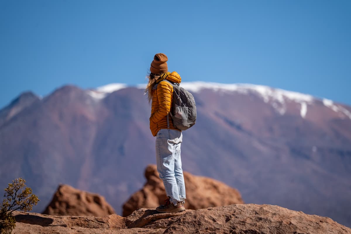 Woman standing in the Valley of Rocks with a purple mountain in the background in the Altiplano of Bolivia