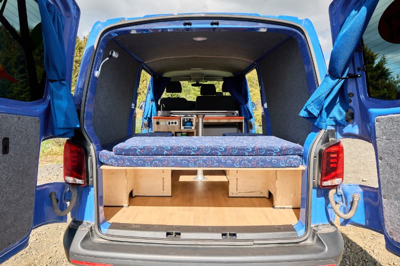 Seating and kitchen setup in the Happy 4x4 campervan model from Happy Campers in Iceland