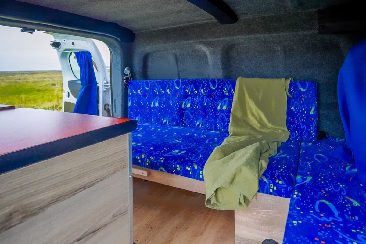 interior view of padded storage bench and couch in a Happy 1 campervan model from Happy Campers in Iceland