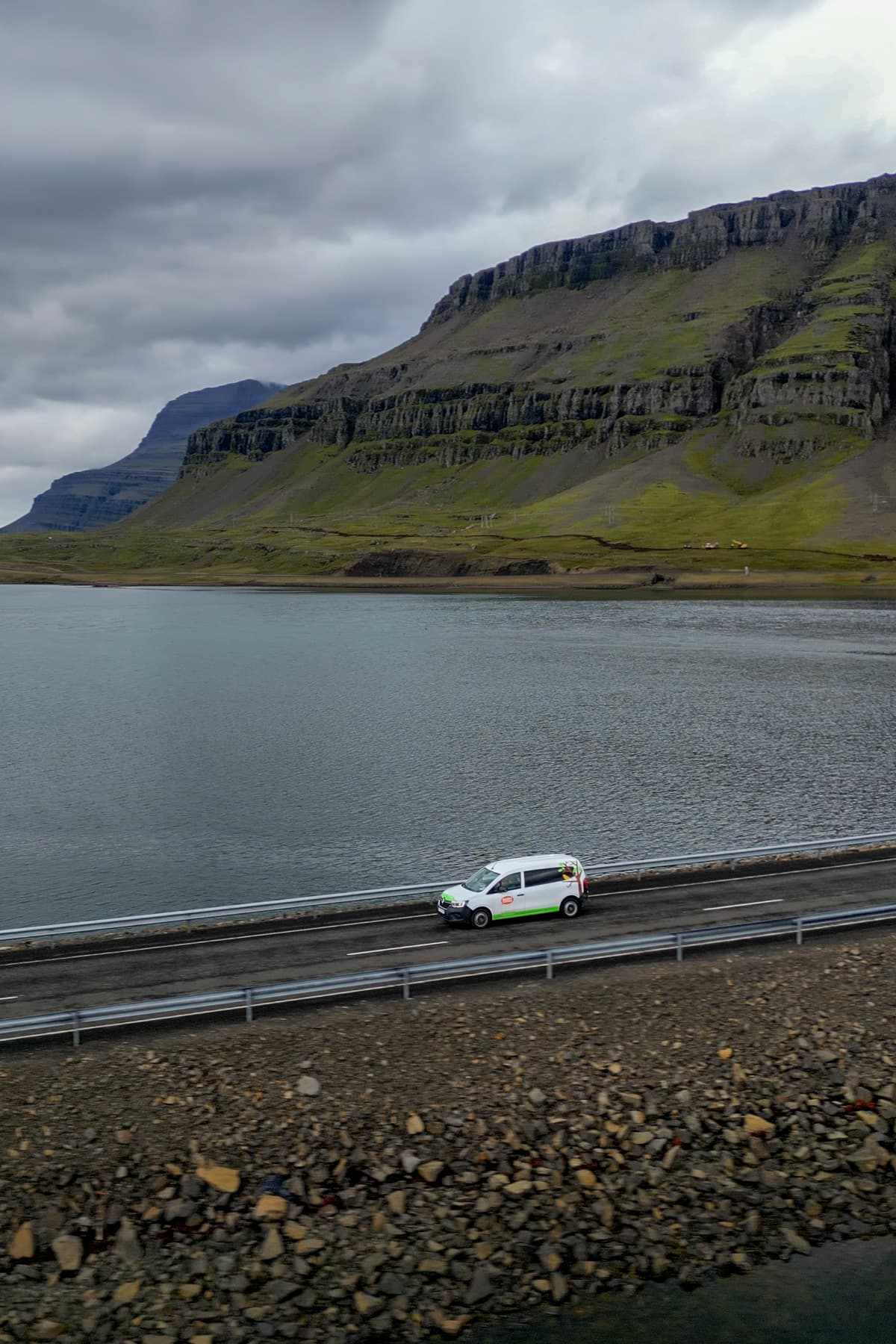 Happy 1 model campervan driving down a road in the east fjords of Iceland