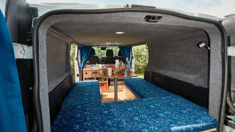 View of the seating arrangement and table in the back of a Happy 2 model of a Happy Campers campervan in Iceland