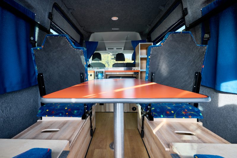 Seating and table arrangement in the Happy 4 XL model of campervan from the Happy Campers rental company in Iceland