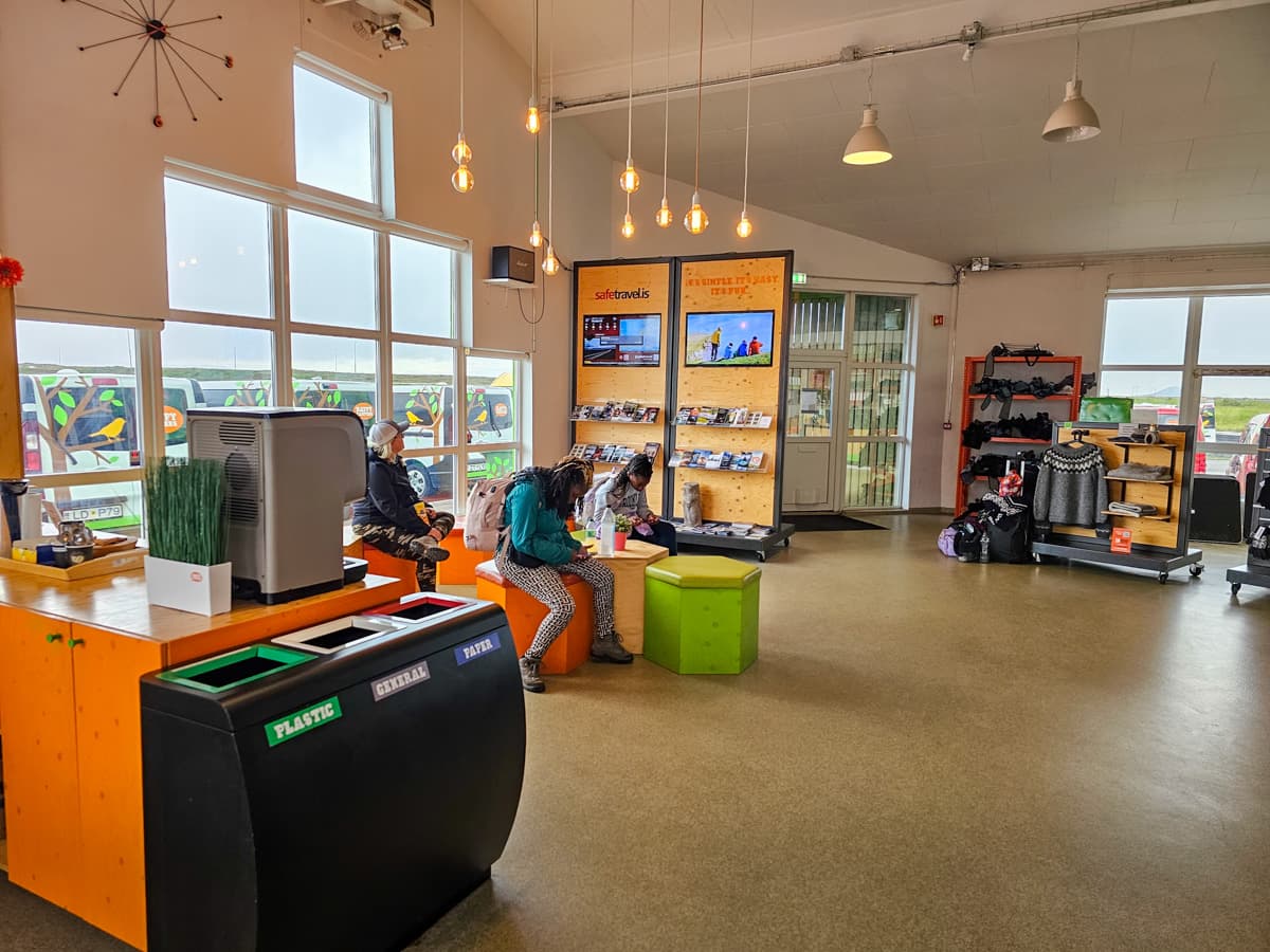 People sitting on stools in the Happy Campers campervan rental office in Iceland