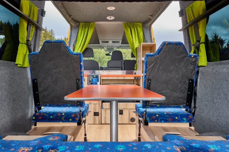 Seating and table setup of the Happy 3 campervan model from Happy Campers in Iceland