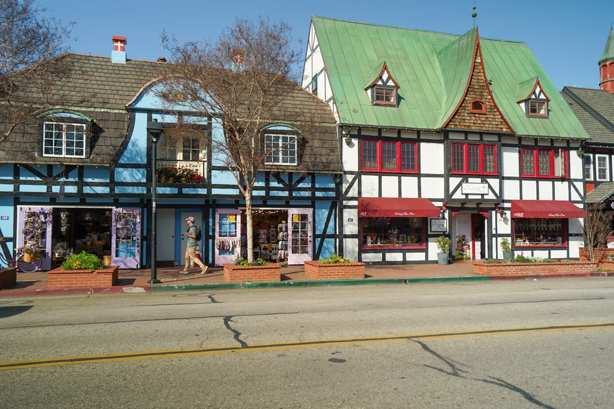 Man walking down the main street with Danish buildings in the background in Solvang, California