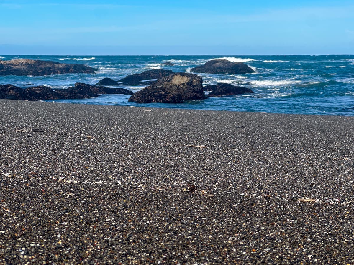 Pebble beach with sea stacks in the background in Glass Beach in Fort Bragg, California
