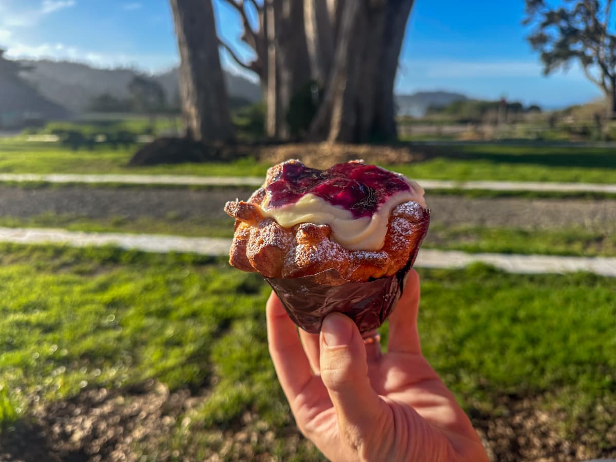 Hand holding a raspberry curd cruffin from GoodLife Bakery in Mendocino, California