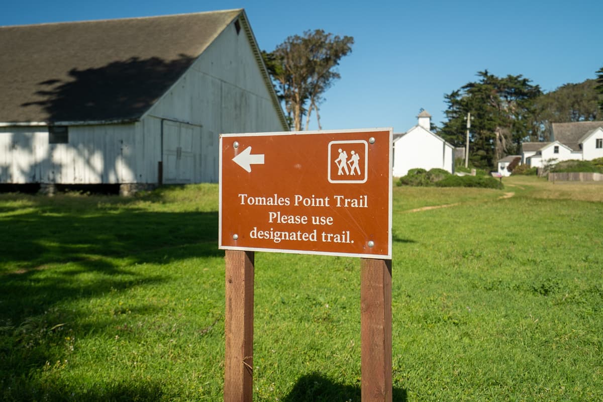 Trailhead sign for the Tomales Point Trail with the Pierce Ranch in the background in Point Ryes National Seashore